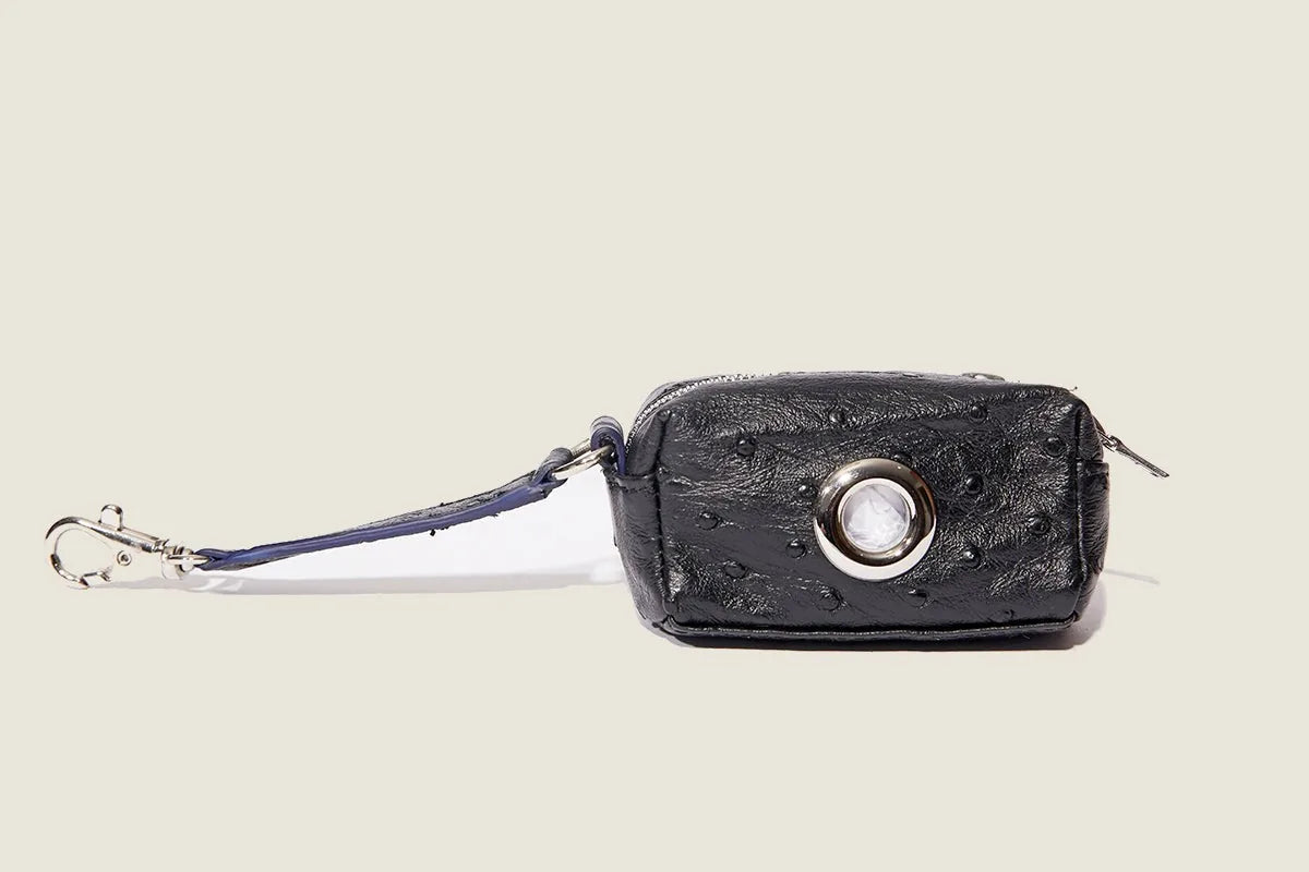 Compact black ostrich-patterned waste bag dispenser with a clip, featuring a metallic opening and durable silicone material.