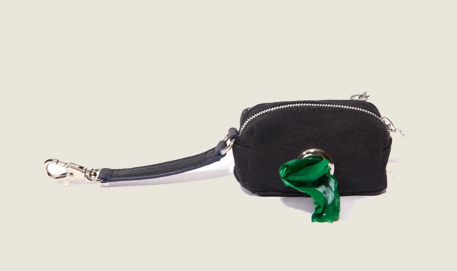 Black ostrich waste bag dispenser with green bag peeking out, featuring a clip and zip closure for easy access.