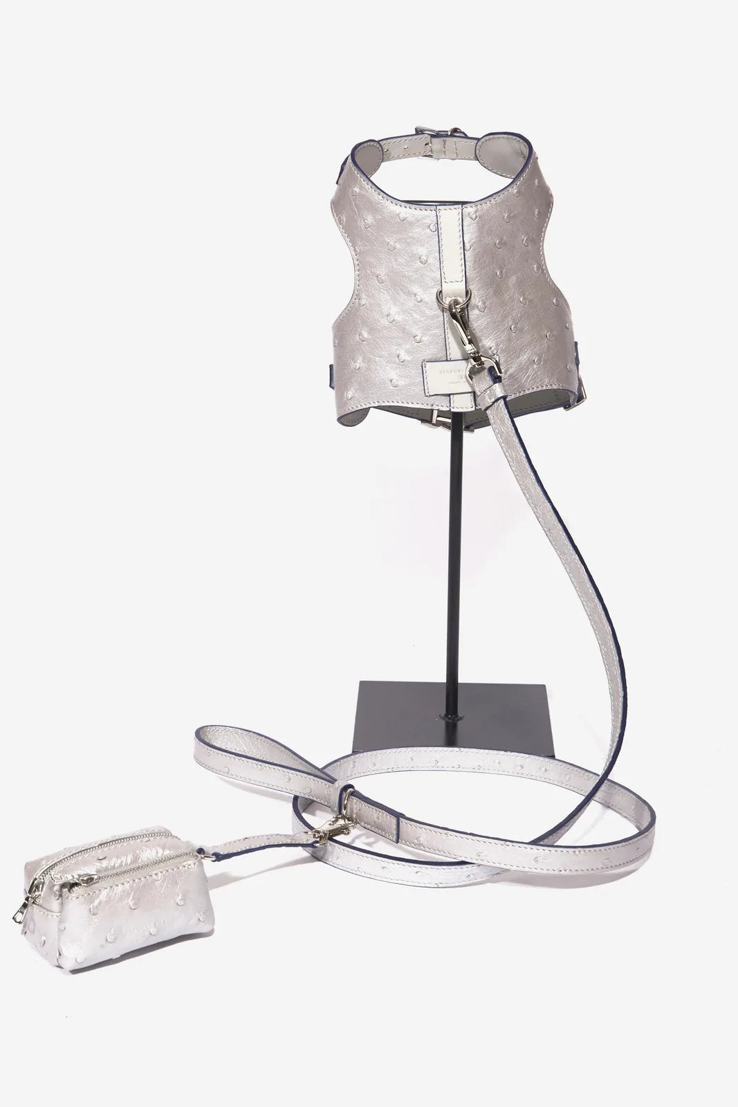 Silver ostrich-patterned waste bag dispenser paired with a matching leash, showcasing its stylish design and functionality.