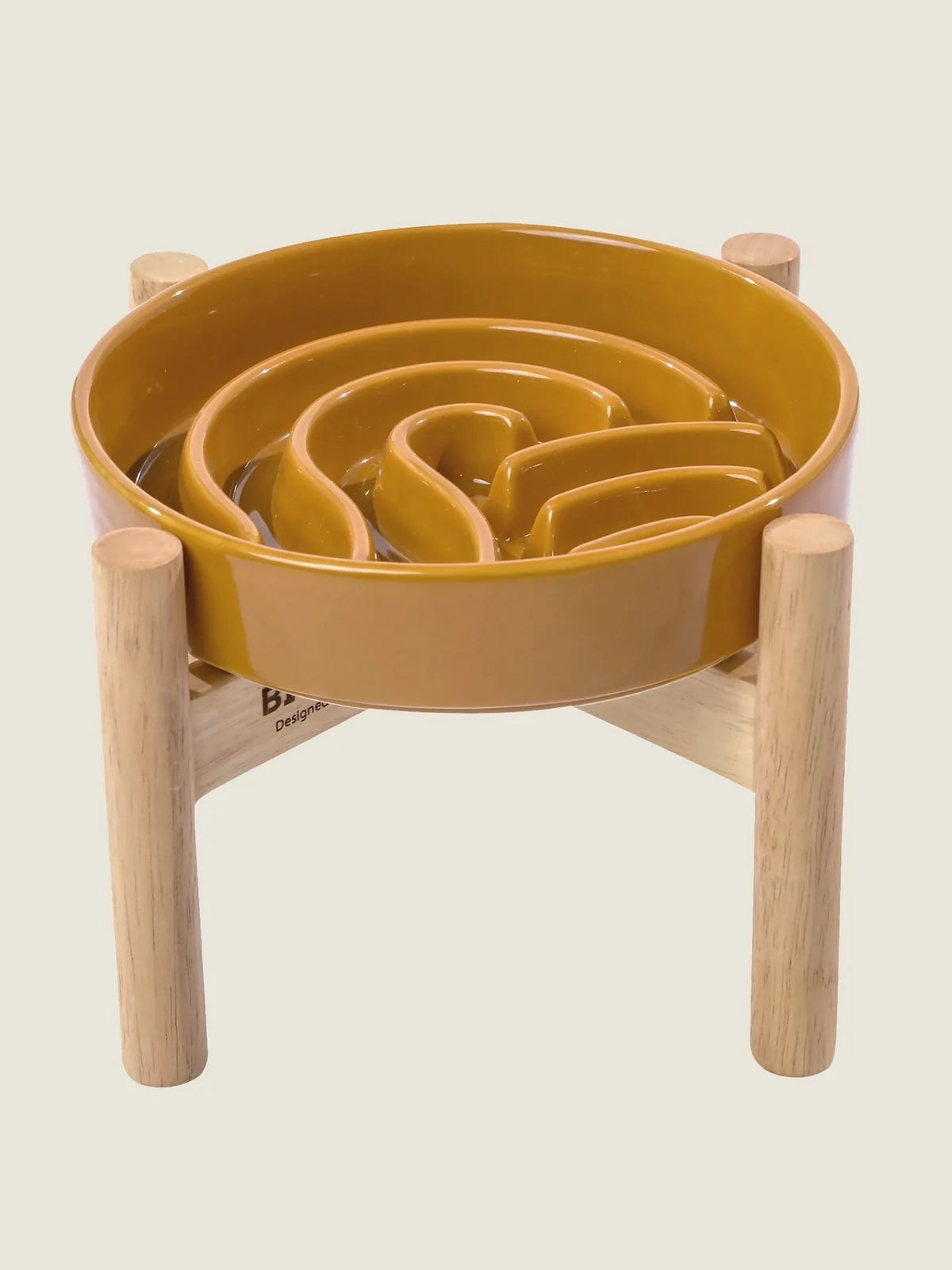 Ceramic slow feeder dog bowl in a warm orange hue, featuring a maze design and wooden stand for enhanced comfort.