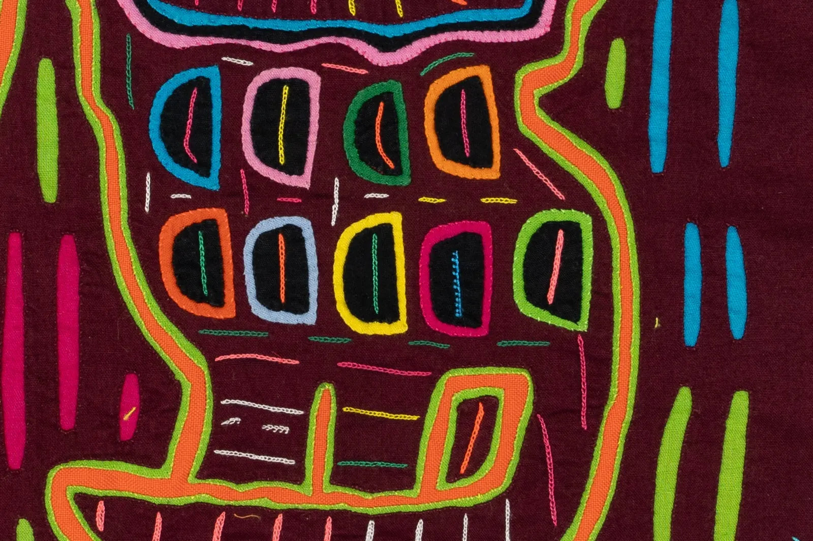 Colorful hand-stitched Mola tapestry featuring geometric patterns in pink, orange, green, blue, and black on deep maroon f...