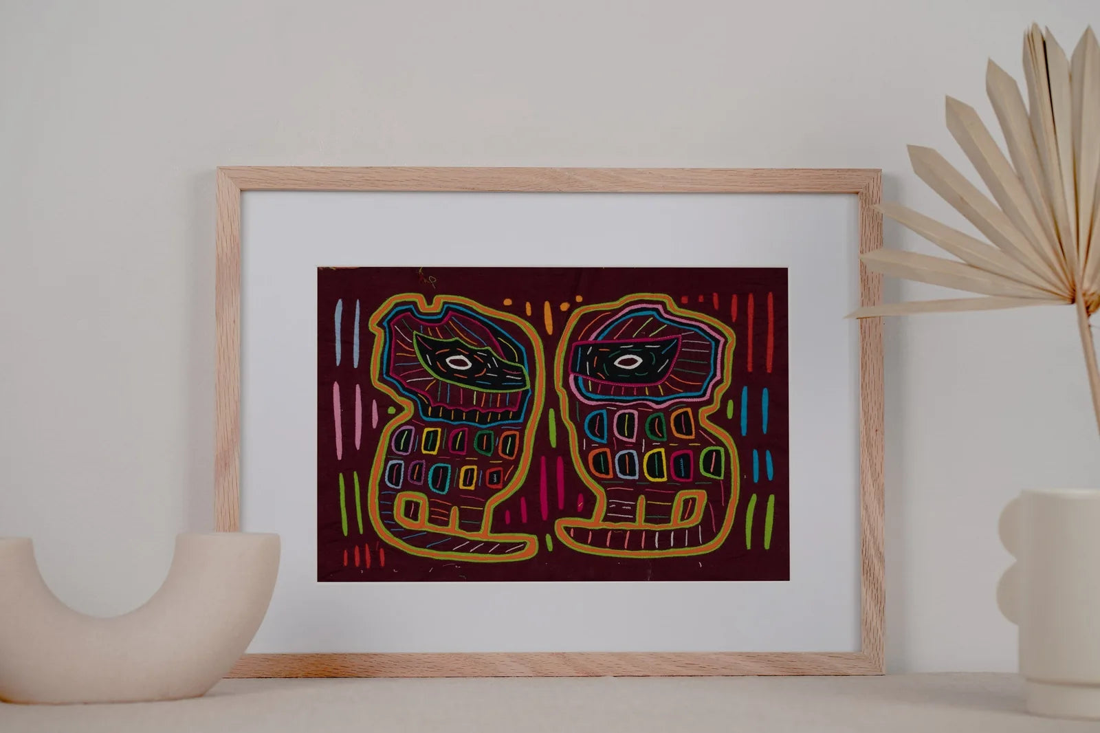Colorful hand-stitched tapestry features two playful dogs against a dark background, highlighting geometric patterns and u...