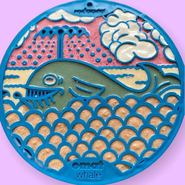 Whale-shaped enrichment lick mat in blue, featuring textured surfaces and suction cups for secure placement.
