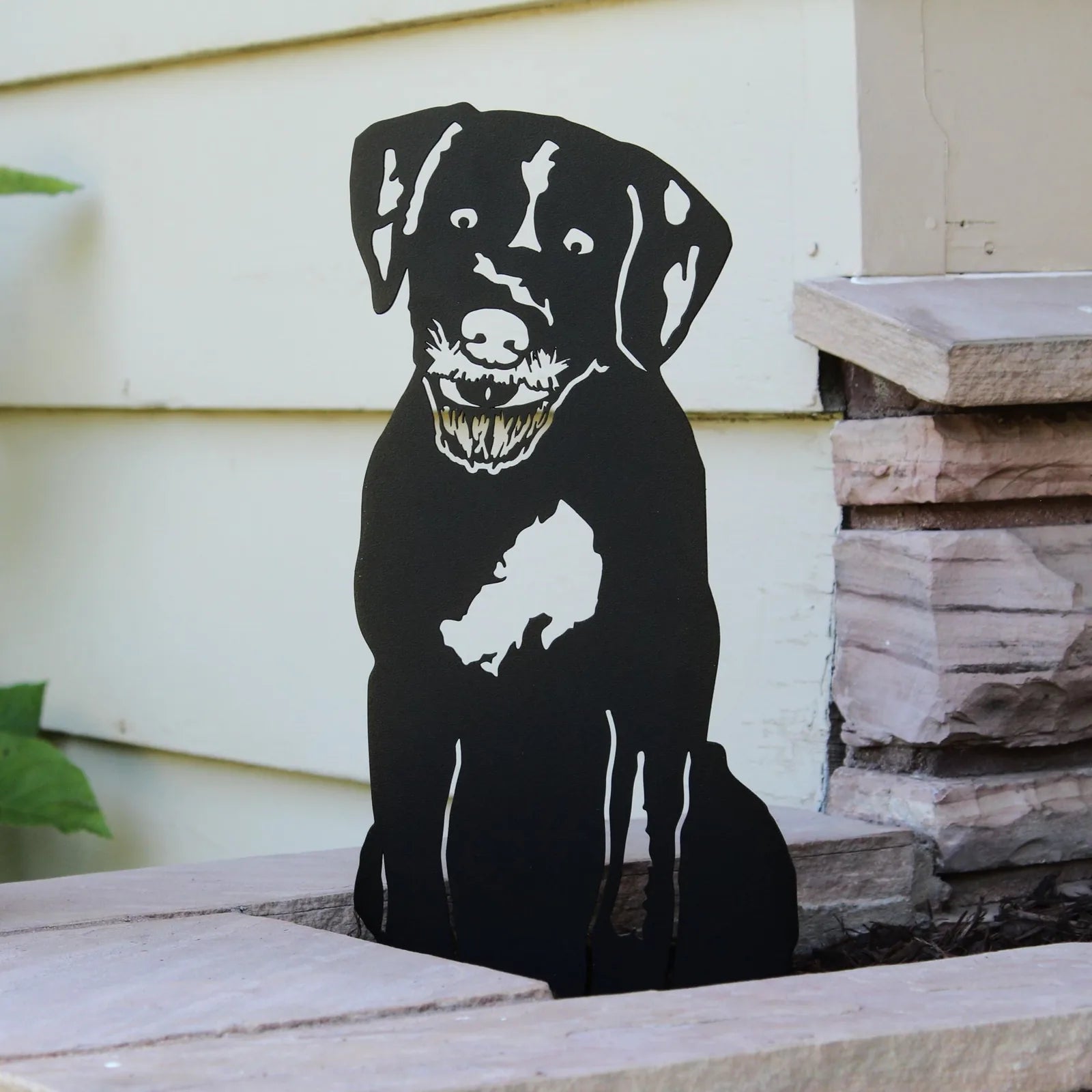 Black metal silhouette of a Wirehaired Pointing Griffon, showcasing detailed features, positioned beside stone steps.