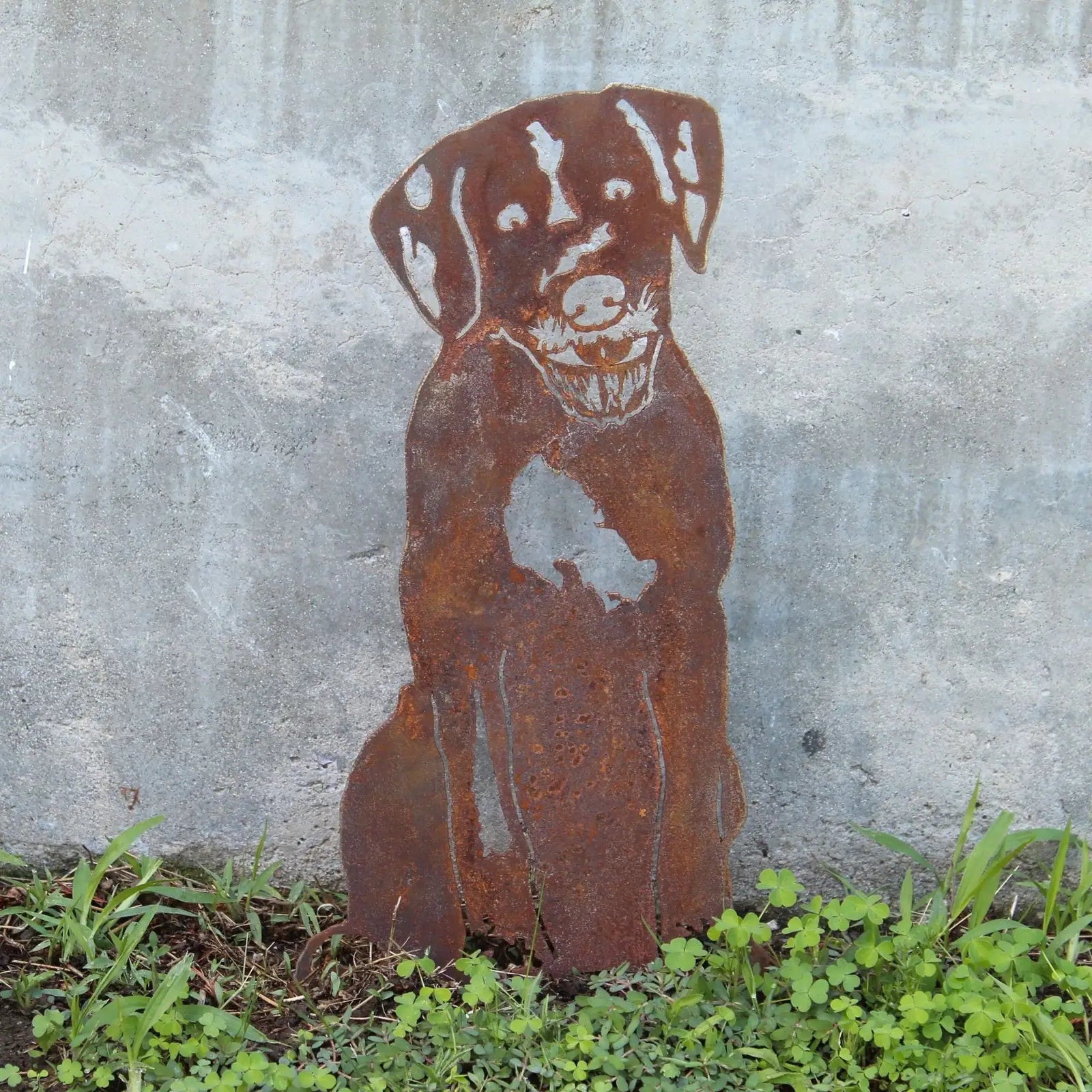 Rusty metal silhouette of a Wirehaired Pointing Griffon sitting against a concrete wall, showcasing its distinctive features.