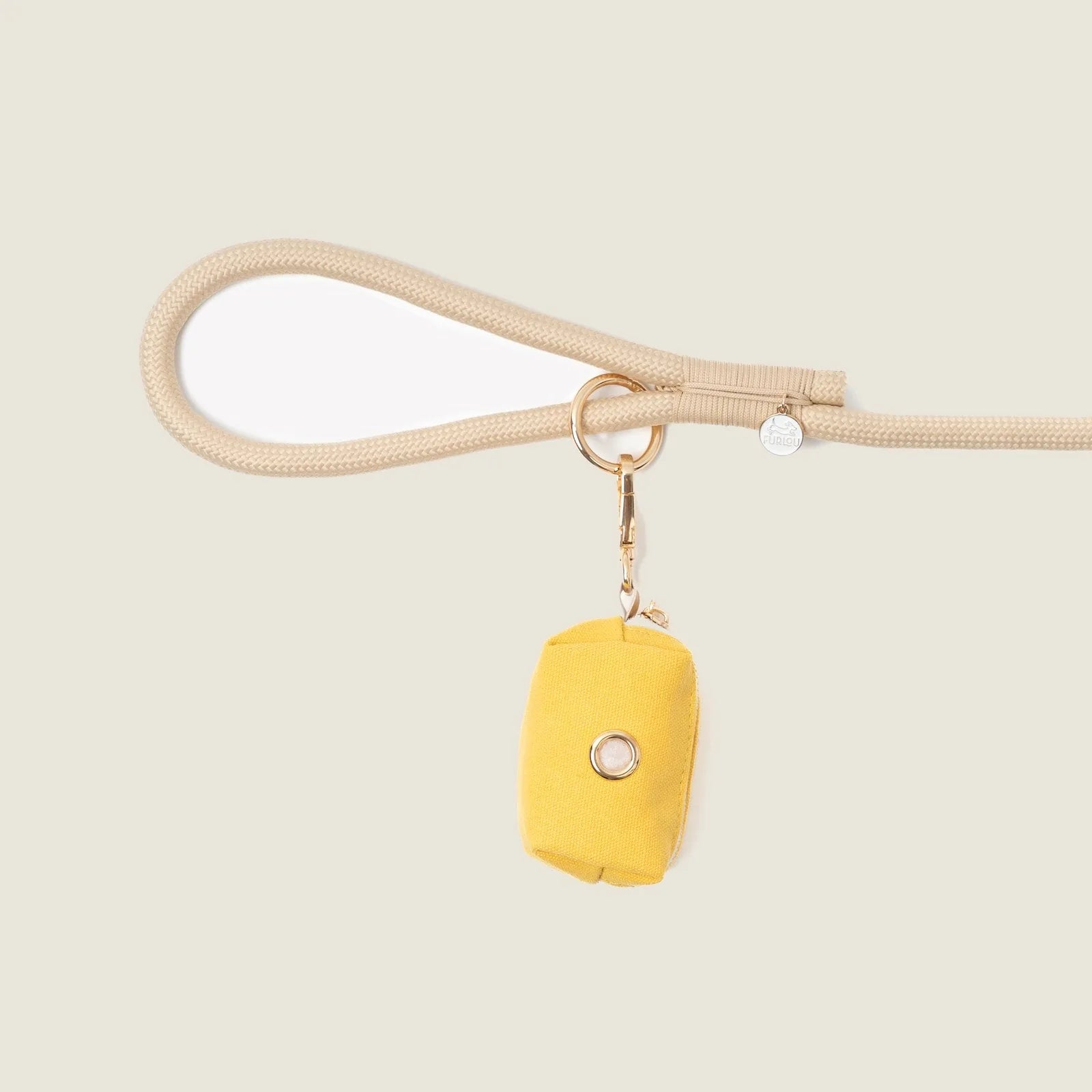 Yellow canvas poop bag holder attached to a beige leash with a gold clip, designed for stylish dog walks.