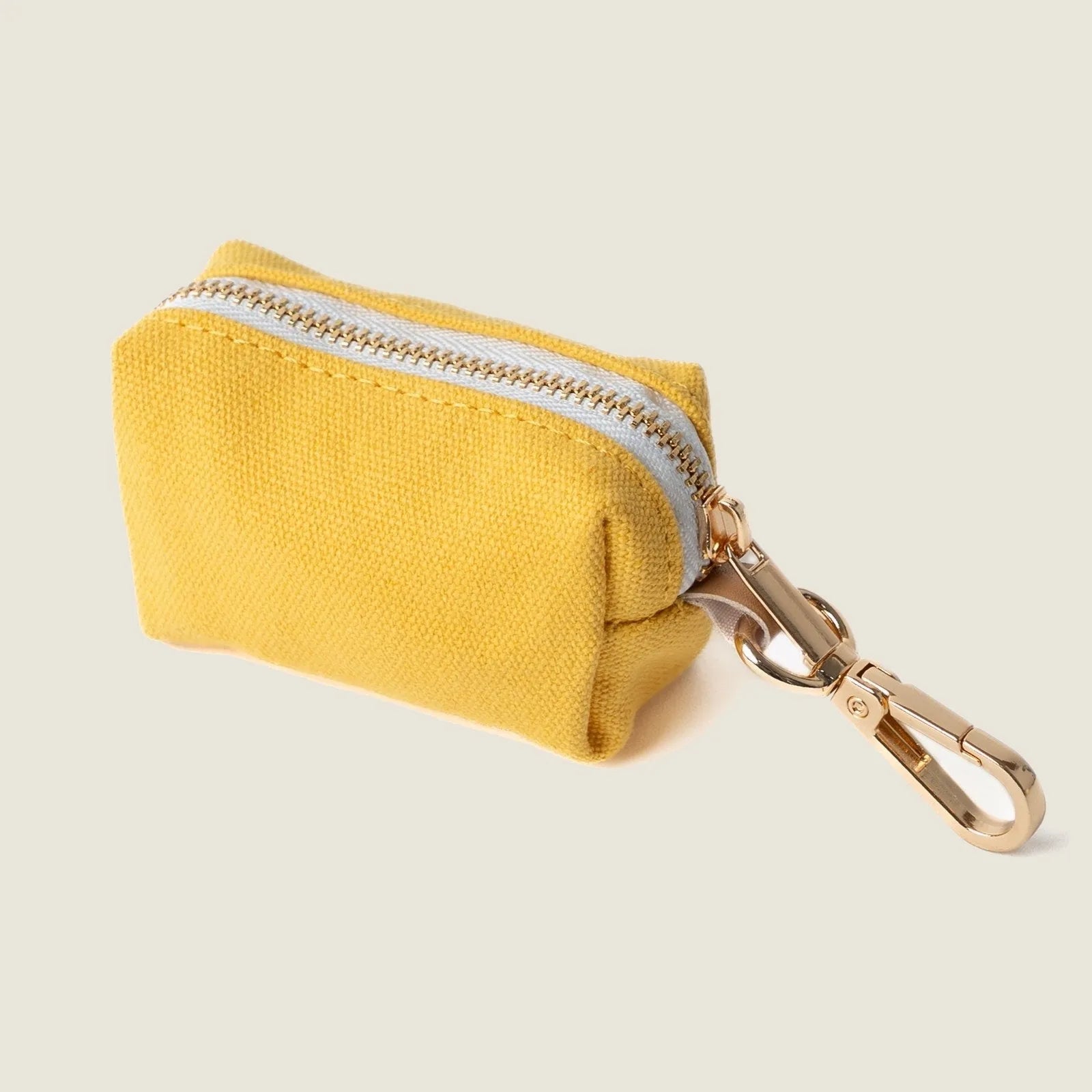 Yellow canvas poop bag holder with a zip closure and gold clip, perfect for walks with your dog.