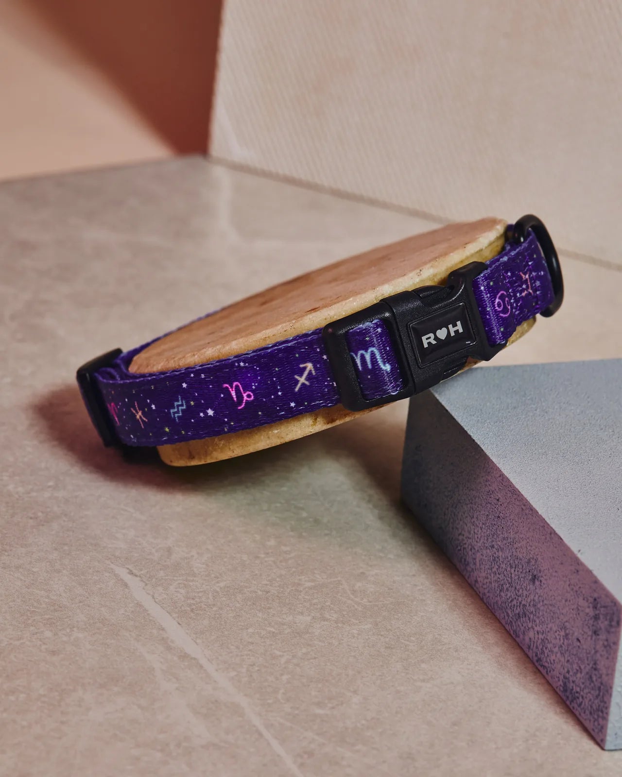 Adjustable purple dog collar with zodiac print, featuring a black buckle and durable fabric with a soft lining.